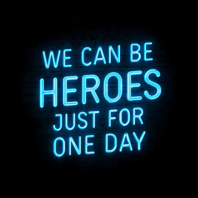 Neon sign with motivational quote 'We can be heroes just for one day' on a dark background, mobile image